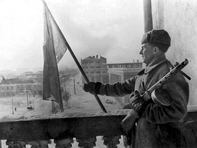 Красноармеец водружает красный флаг над гостиницей «Воронеж» на площади имени 20-летия Октября (ныне – площадь Ленина) (25 января 1943 года)